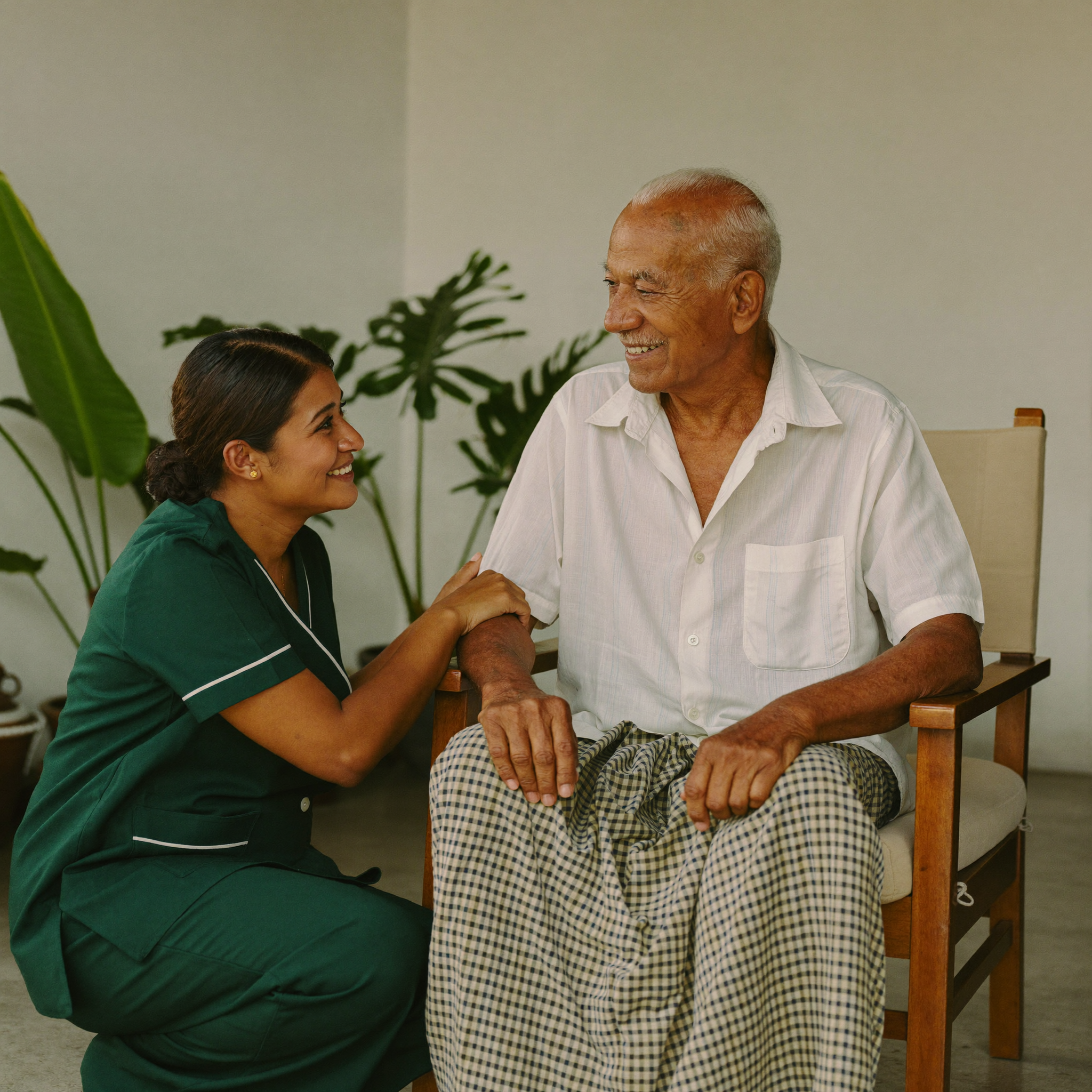 Sri Lankan caregiver in green uniform with an elderly man at home
